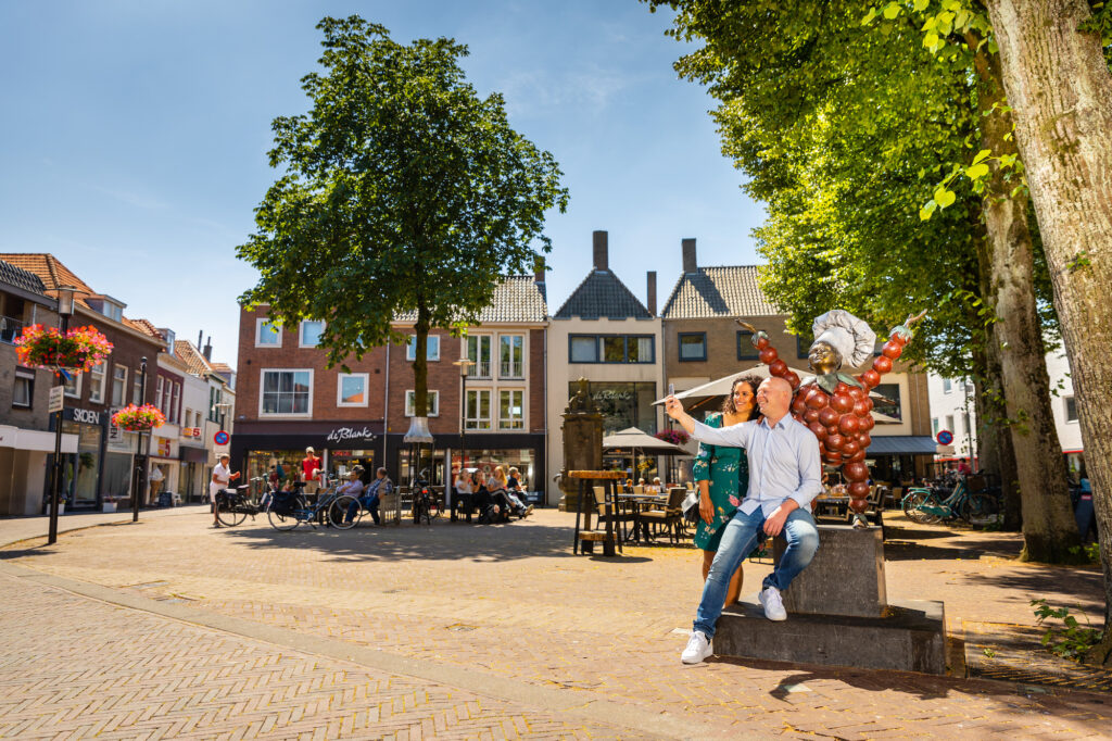 Mensen op de markt bij het standbeeld van Flipje in Tiel