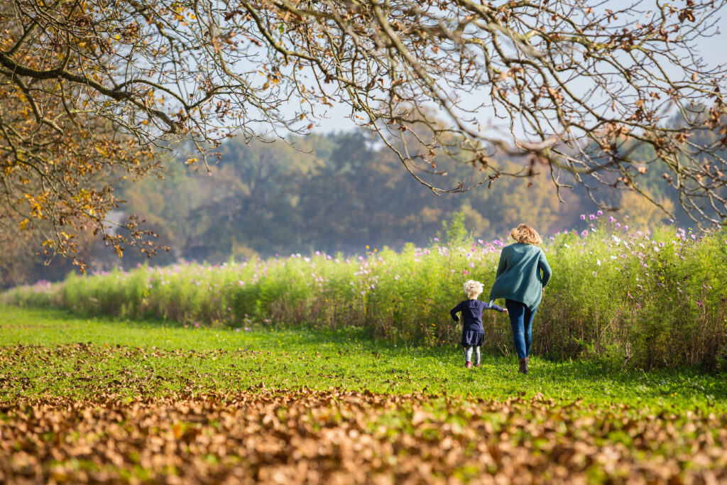 Moeder met kind wandelt in herfst in Rivierenland