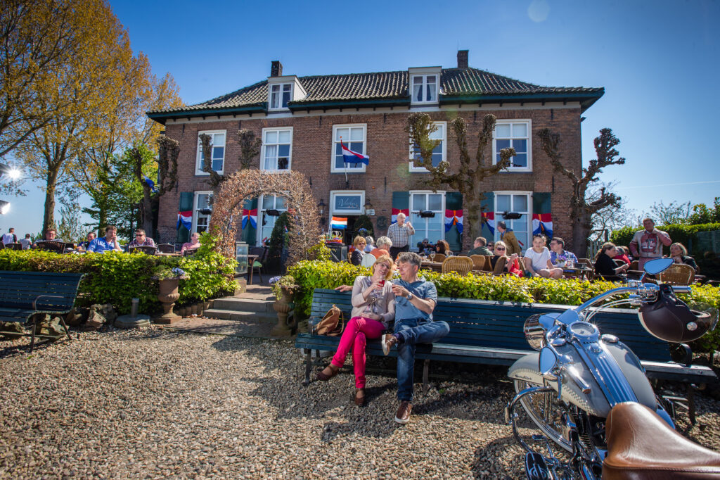 mensen op bankje bij 't veerhuis in Opheusden in Neder-Betuwe